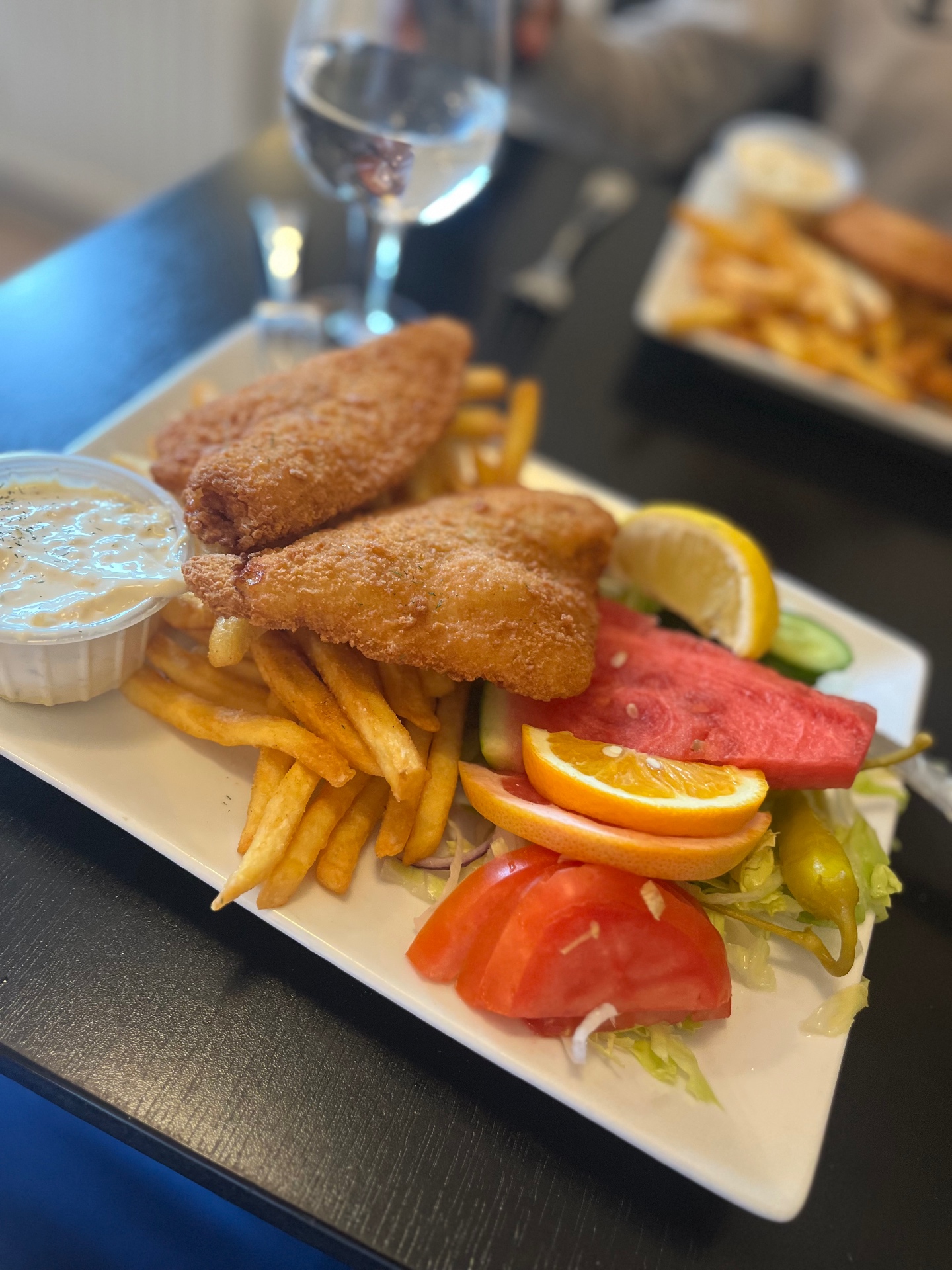 Pannerad fisk med pommes frites, sallad och frukt